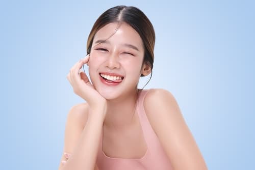 A young woman with a radiant smile and bright white teeth, showcasing the result of blue light teeth whitening